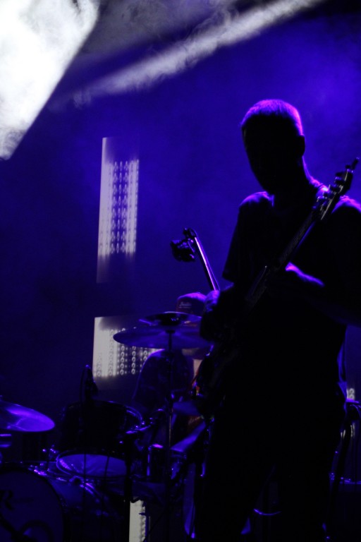w cieniu, gitarzysta, w odcieniach niebieskiego. Występ na scenie.