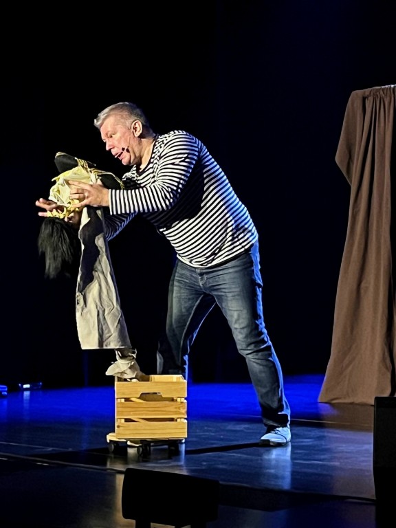 występ sceniczny, mężczyzna w koszuli w paski, teatr lalek, na scenie statek piracki