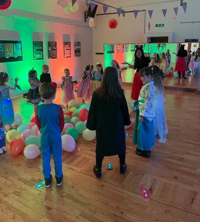 Zabawa dla dzieci, dzieci w przebraniach stoją w kole. W środku koła - balony.