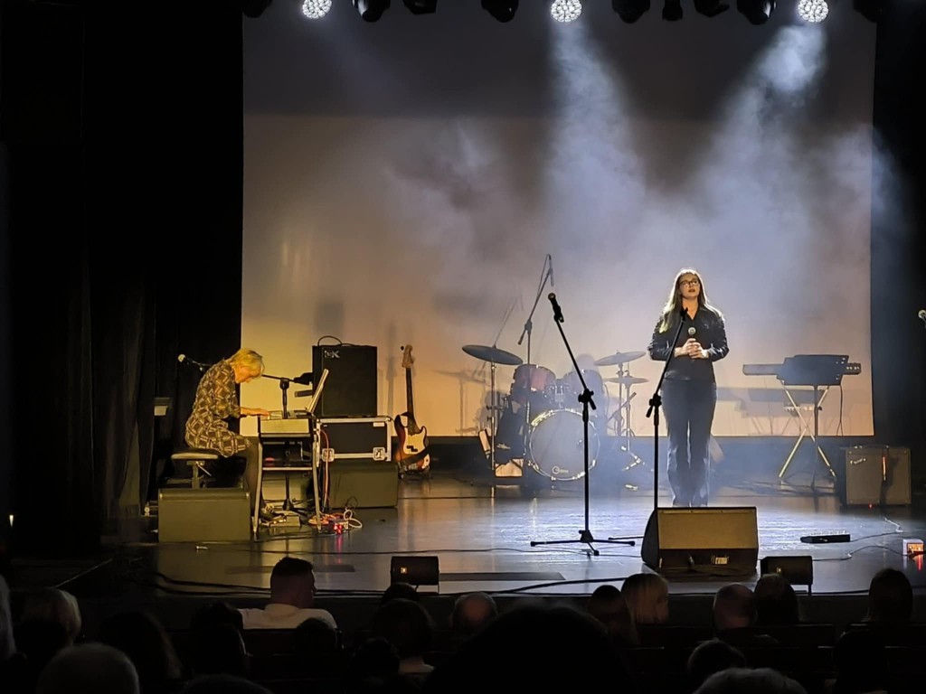 występ sceniczny, przy klawiszu pianistka. Towarzyszy jej dziewczyna - wokalistka.