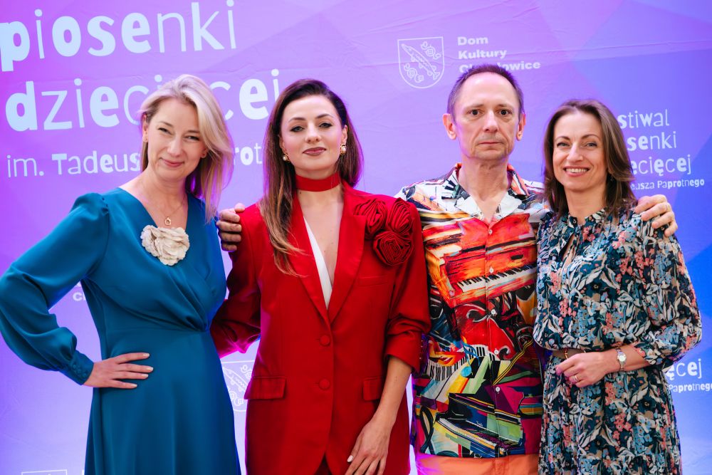 4 osoby dorosłe na tle ścianki festiwalowej