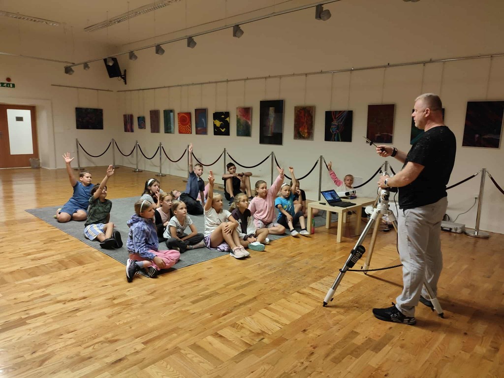 Dzieci słuchają prowadzącego i zgłaszają się do odpowiedzi.