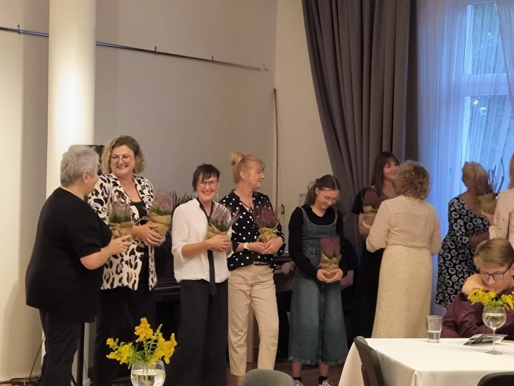 2.	Grupa kilku kobiet odbiera kwiaty.