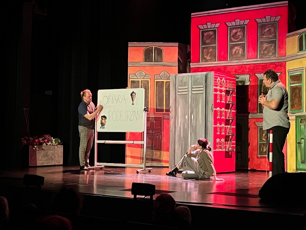 sytuacja sceniczna, mężczyzna przy tablicy tłumaczy to 2 osobom.