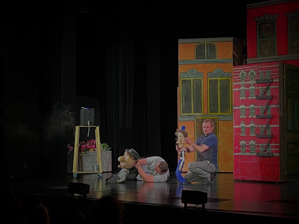 sytyacja sceniczna, dwóch mężczyzn animuje lalki.