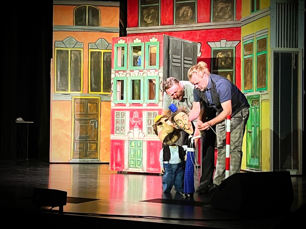 sytuacja sceniczna, dwóch mężczyzn animuje lalki.