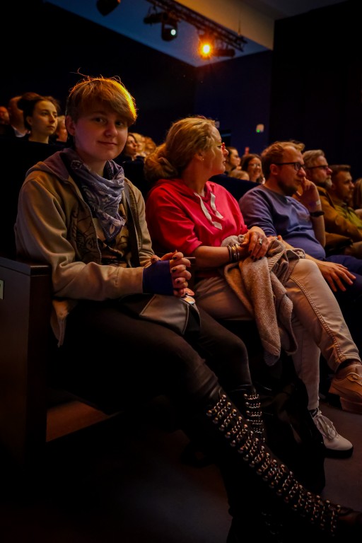  Fragment publiczności, jedna z kobiet patrzy bezpośrednio w obiektyw