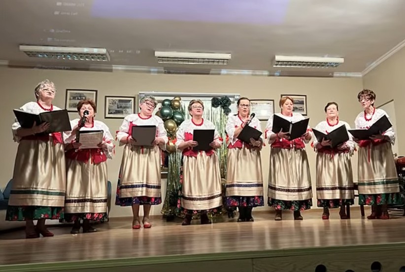 grupa kobiet w ludowych strojach podczas występu śpiewaczego