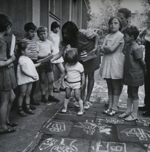 Dzieci bawiące się na betonie z narysowanymi kredą rysunkami