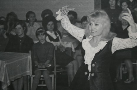 Kobieta wykonująca występ przed publicznością na krzesłach