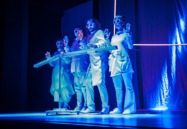 aktorzy stojący na scenie w niebieskiej ultrafioletowej  poświacie