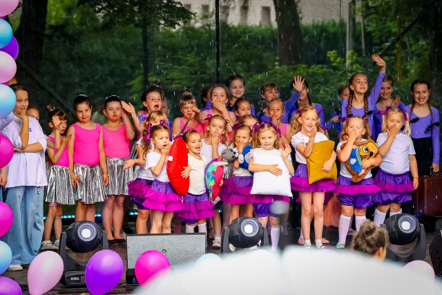 zdjęcie grupowe, na scenie spora grupa dzieci macha w kierunku widowni
