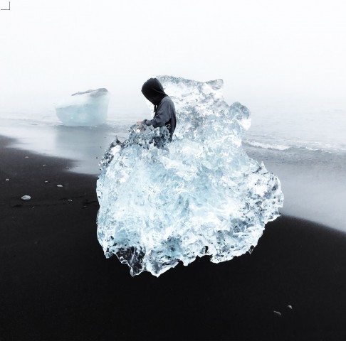 osoba w lodowej bryle na czarnej plaży