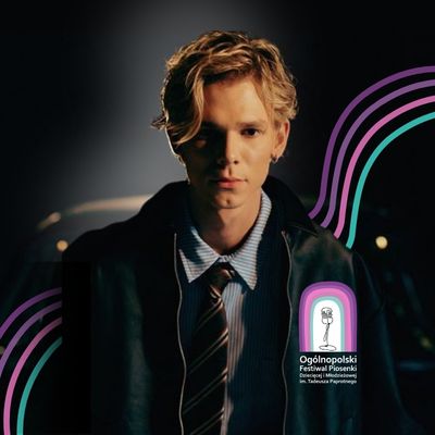 młody mężczyzna, w tle falujące linie po prawej logo