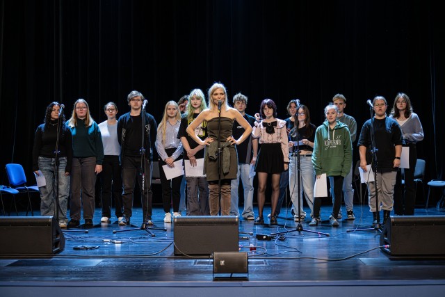 grupa młodzieży na scenie, na pierwszym planie kobieta