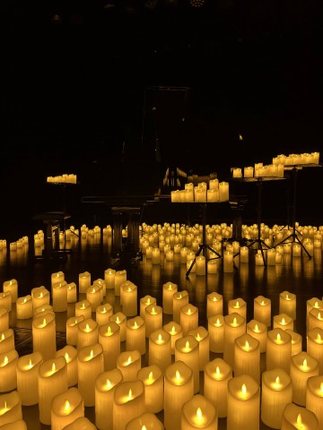 na scenie fortepian otoczony świecami