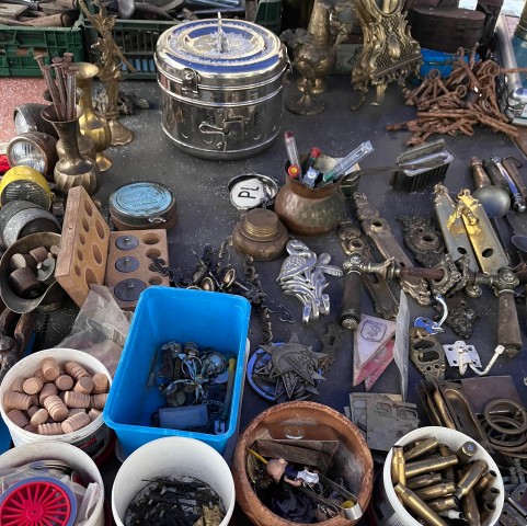 starocie, metalowe elementy w plastikowych wiaderkach i rozłożone na ziemu,