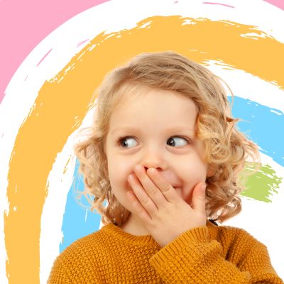 Małe dziecko uśmiecha się i patrzy w prawo, zasłania dłoń rączką. W tle pastelowe mazy.