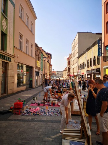 Ulica z wystawcami podczas jarmarku. W tle rynek miasta.