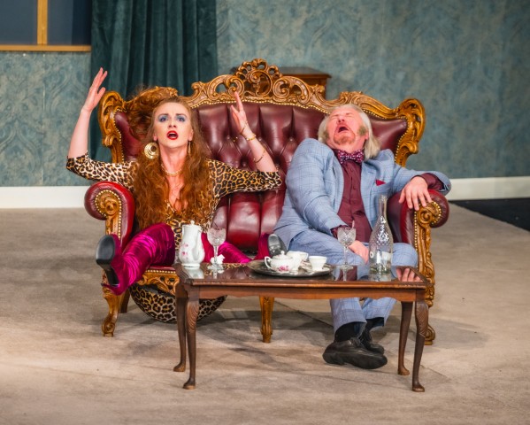 Dwie osoby na kanapie przed nimi stolik kawowy