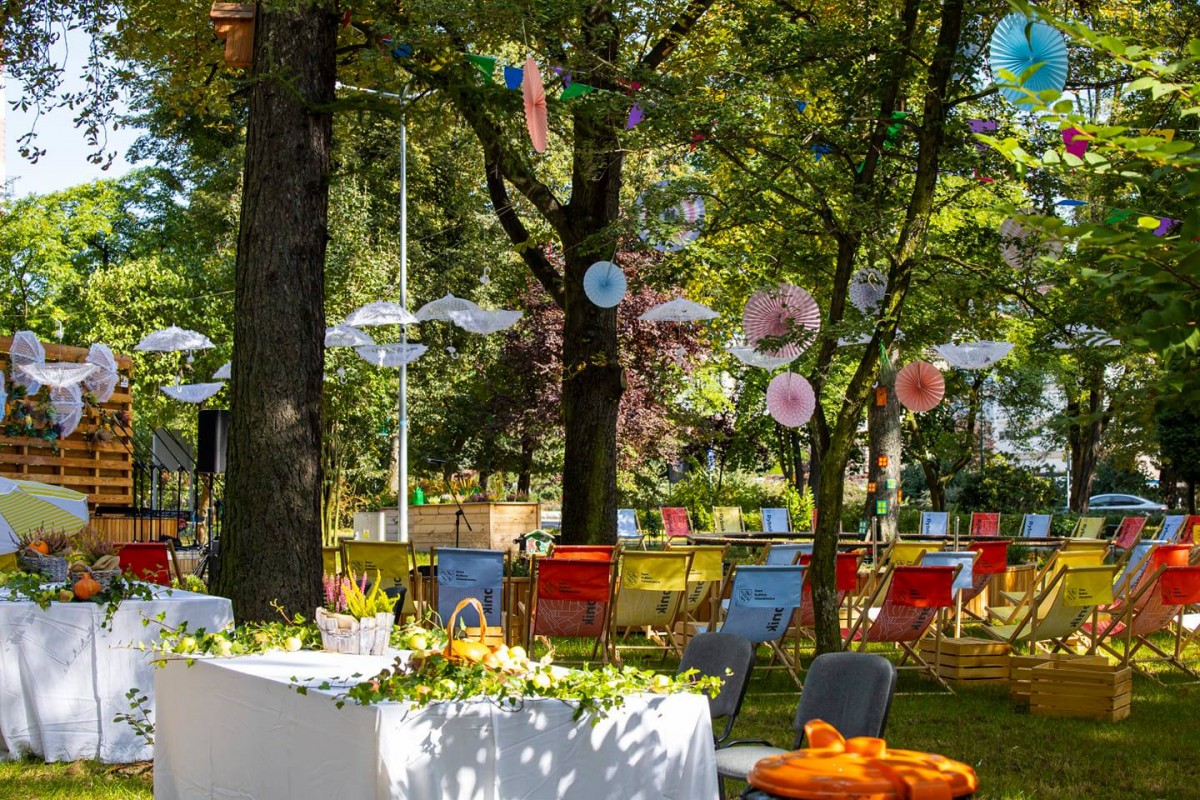 Zdjęcie Ogrodu Społecznego, znajdują się tam stoliki, krzesła i ozdoby